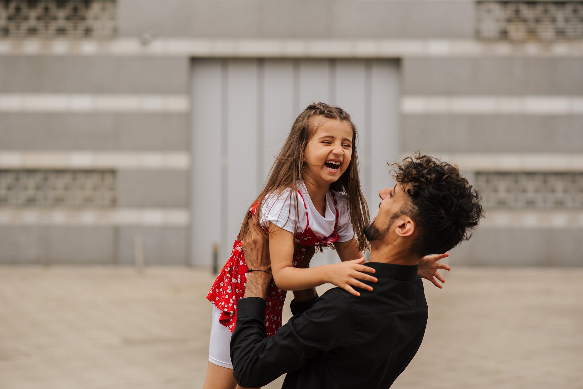 father holding daughter in hands on street